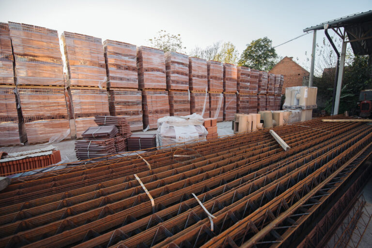 Briques et ferraillage stockés sur un chantier de construction, illustrant le secteur du BTP