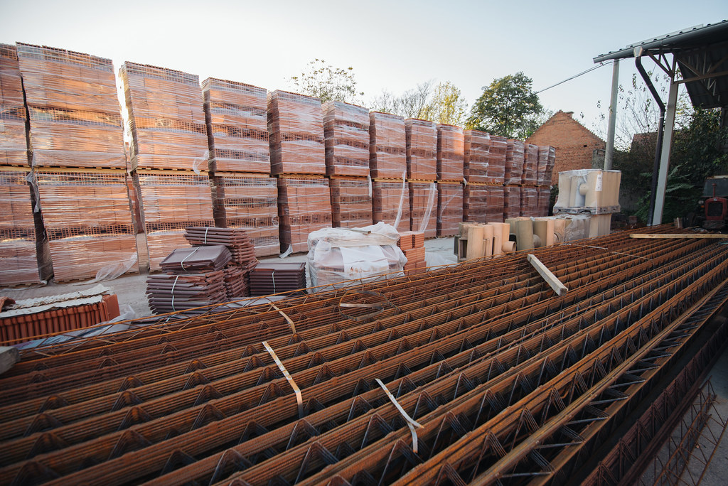 Briques et ferraillage stockés sur un chantier de construction, illustrant le secteur du BTP