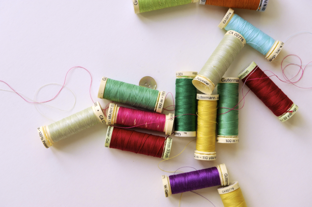 Plusieurs bobines de fil de couleurs différentes, symbolisant le choix entre plusieurs matériaux