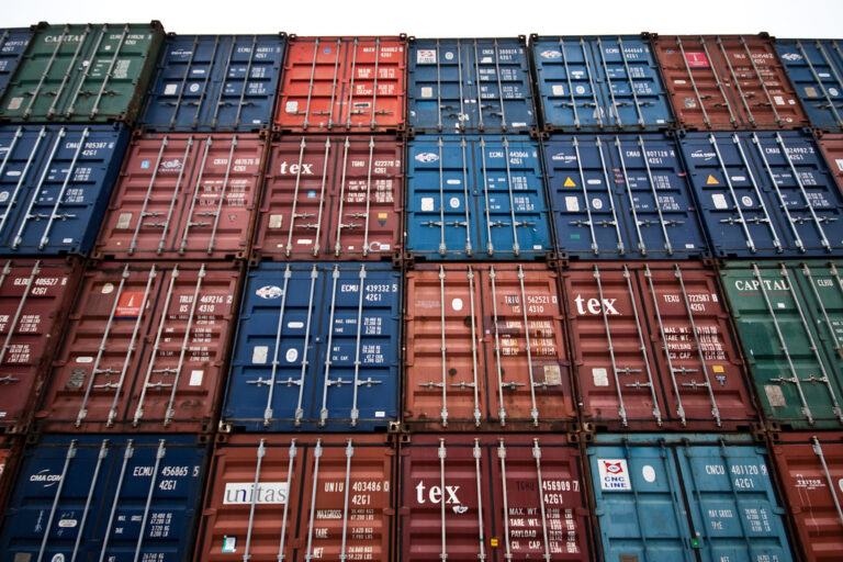 Conteneurs maritimes de différentes couleurs empilés dans un port