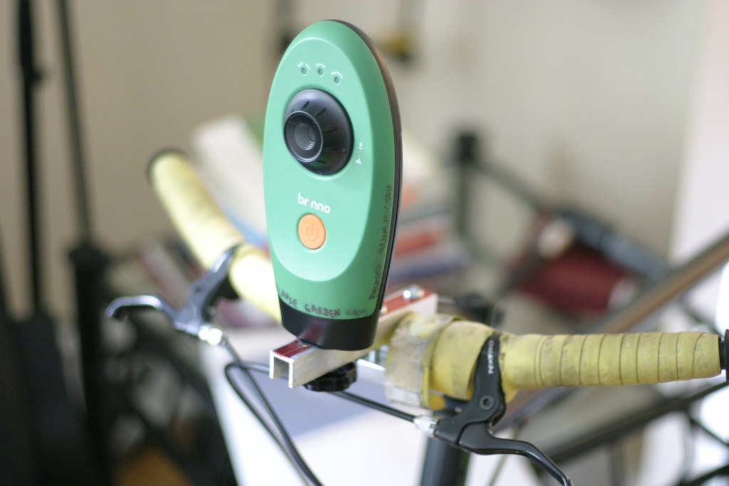 Petit appareil fixé sur un guidon de vélo via un support de fixation sur mesure, illustrant les accessoires de cyclisme adaptés au cintre