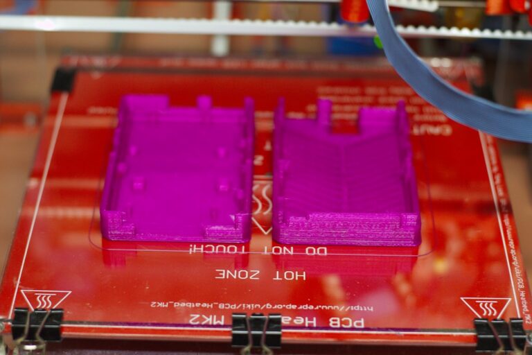 Deux boîtiers en plastique à parois fines venant d'être imprimés en 3D, illustrant le sujet de l'épaisseur de paroi minimale