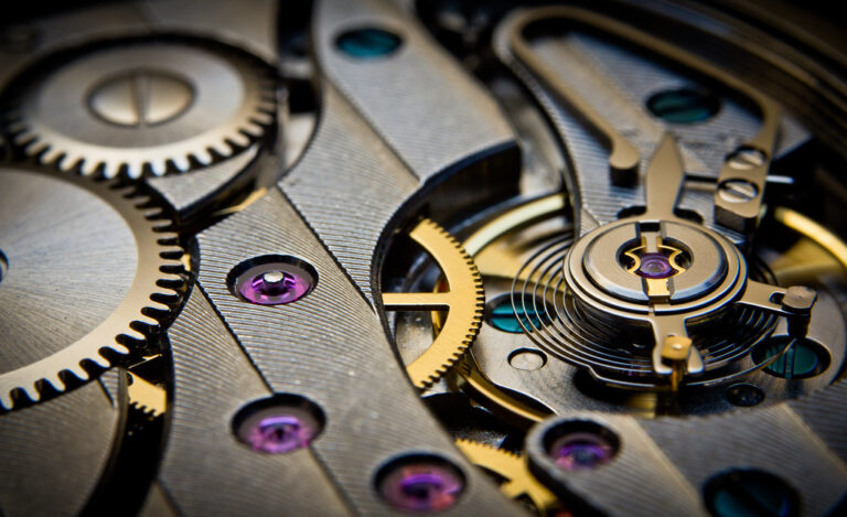Rouages et mécanisme d'un mouvement de montre vus en macro, illustrant la précision extrême de l'horlogerie