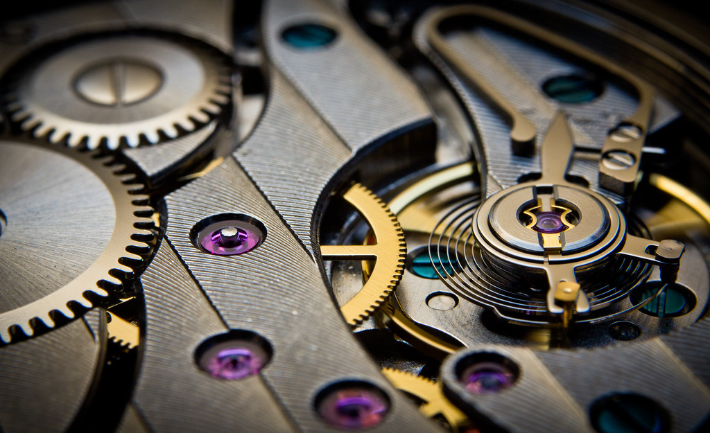 Rouages et mécanisme d'un mouvement de montre vus en macro, illustrant la précision extrême de l'horlogerie