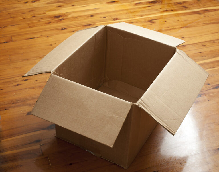 Carton d'expédition ouvert, illustrant la réception d'une commande de pièces imprimées en 3D