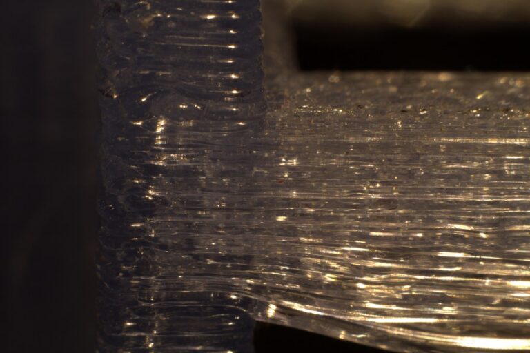 Vue macro d'une pièce imprimée en 3D montrant la structure en couches successives, illustrant l'impact de l'orientation d'impression