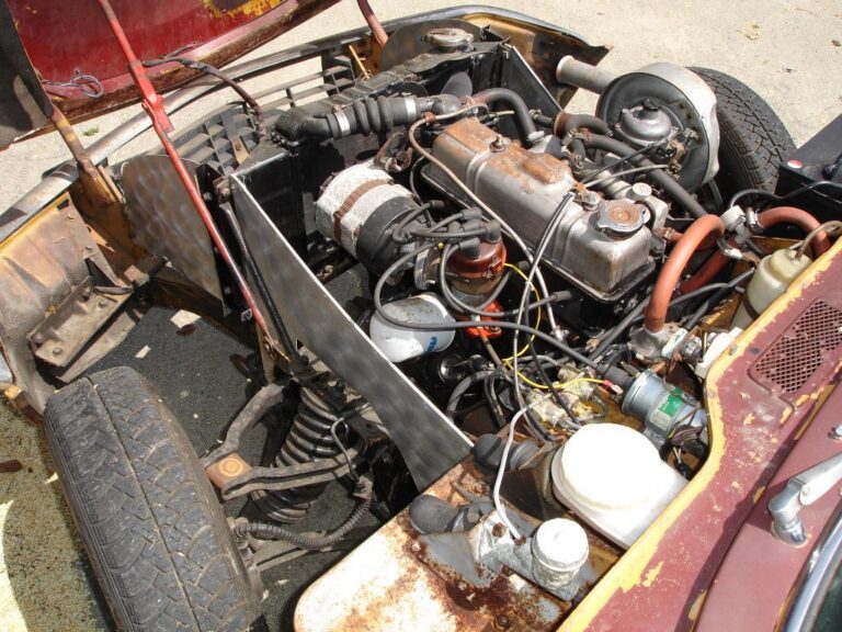 Compartiment moteur de voiture avec pièces mécaniques et durites, illustrant un usage typique du nylon renforcé fibre de verre