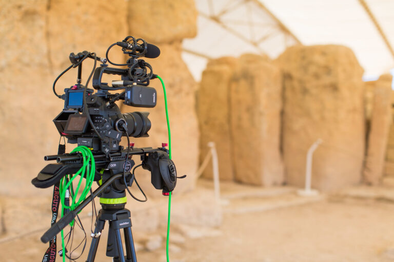 Caméra professionnelle équipée de rails, poignée et micro sur un trépied, illustrant les accessoires sur mesure pour la vidéo