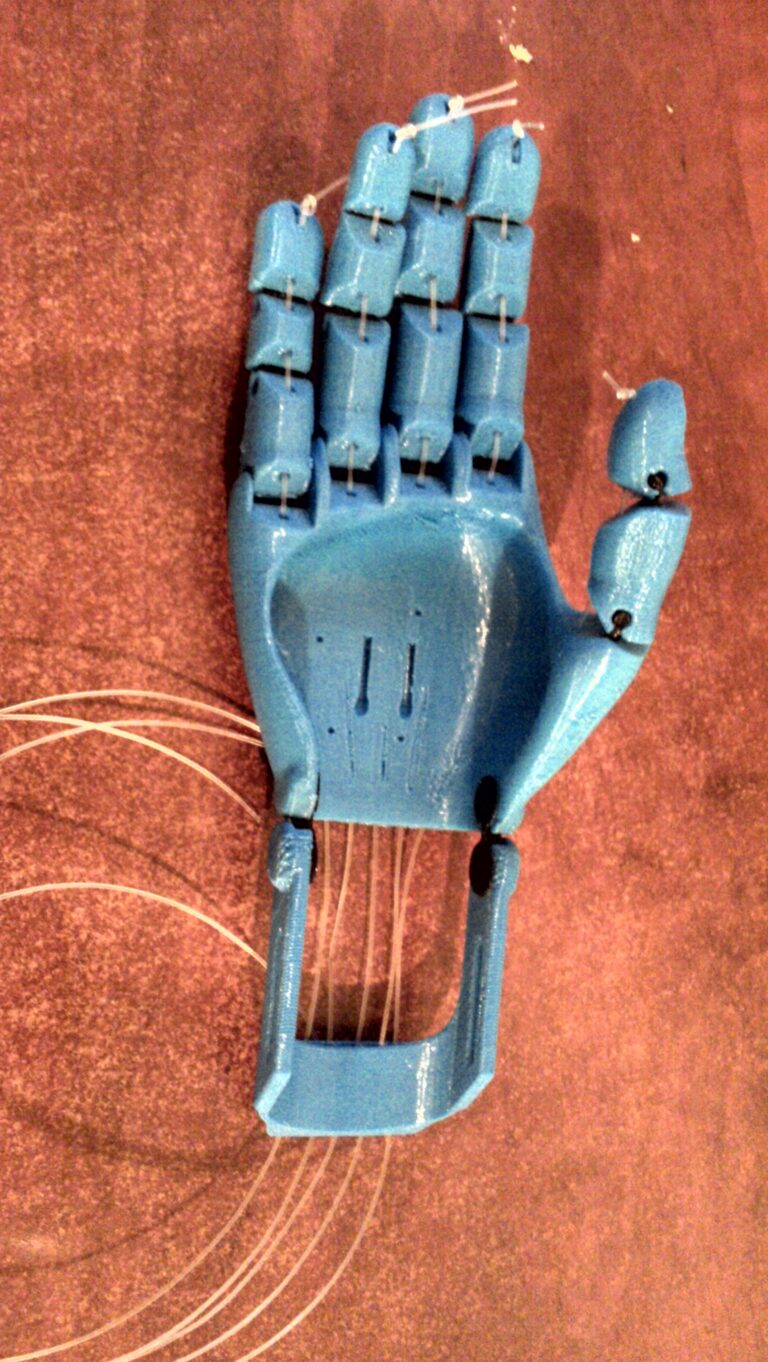 Main prothétique imprimée en 3D avec articulations aux doigts, illustrant une pièce mécanique articulée