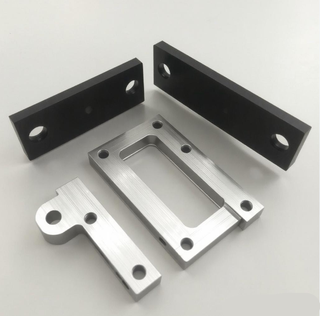Pièces métalliques usinées en aluminium et acier, illustrant la résistance mécanique du métal face au plastique imprimé