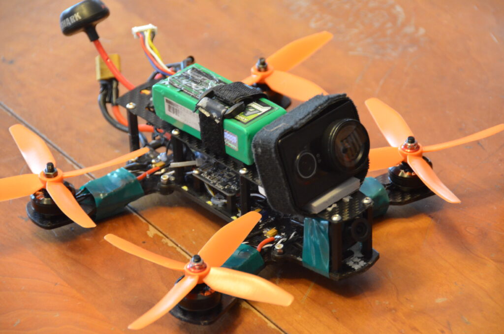 Drone de course avec structure légère en fibre de carbone et caméra embarquée, illustrant un usage typique de la réduction de poids en conception de pièces