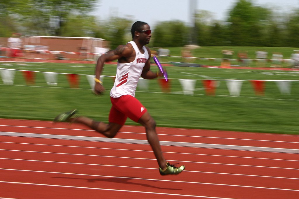 Coureur en pleine vitesse sur une piste d'athlétisme, illustrant l'urgence et le délai de fabrication express